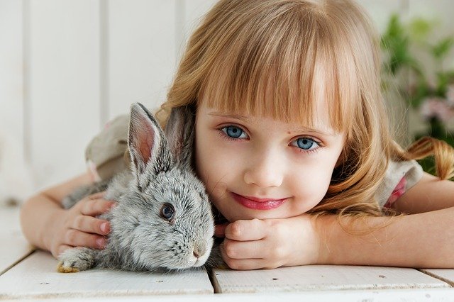 Usmívající se malá dívka, držící králíka